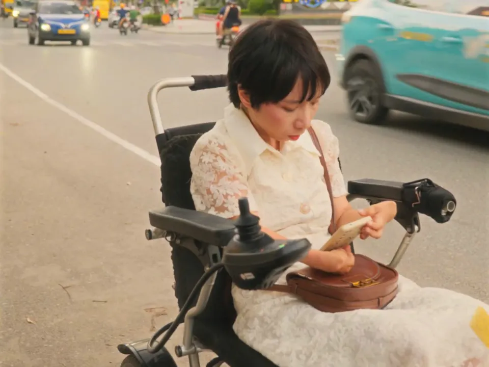 An ngồi trước con phố đông đúc trong phim ngắn ĐỢI
